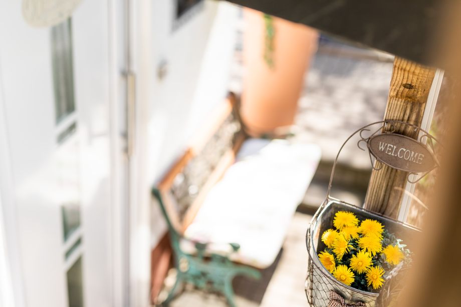 Eingangbereich mit Blumen und Bank zum Sitzen und Warten 